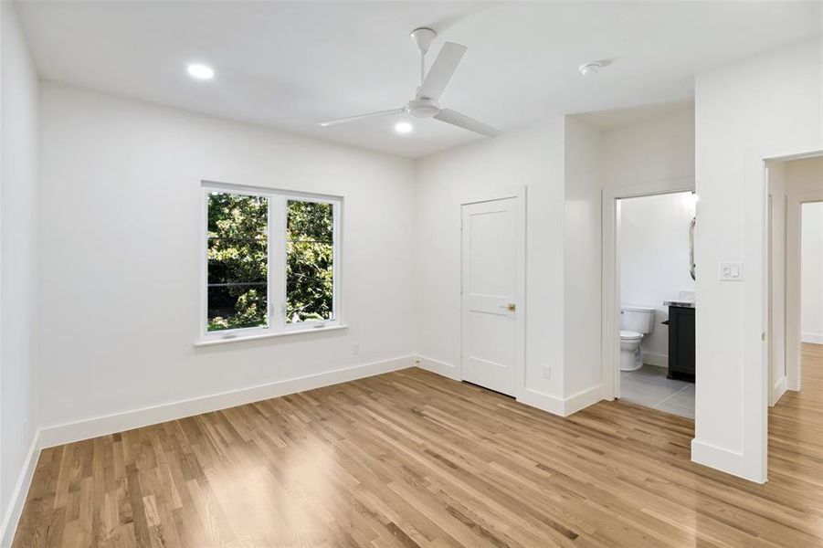 Spacious room featuring wood-finish flooring, recessed lighting, and a contemporary ceiling fan Spacious room featuring wood-finish flooring, recessed lighting, and a contemporary ceiling fan