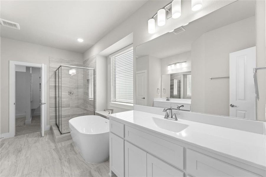 Contemporary bathroom featuring a freestanding soaking tub, a frameless glass shower enclosure with tiled walls, and a dual-sink vanity with white cabinetry and a solid surface countertop Contemporary bathroom featuring a freestanding soaking tub, a frameless glass shower enclosure with tiled walls, and a dual-sink vanity with white cabinetry and a solid surface countertop