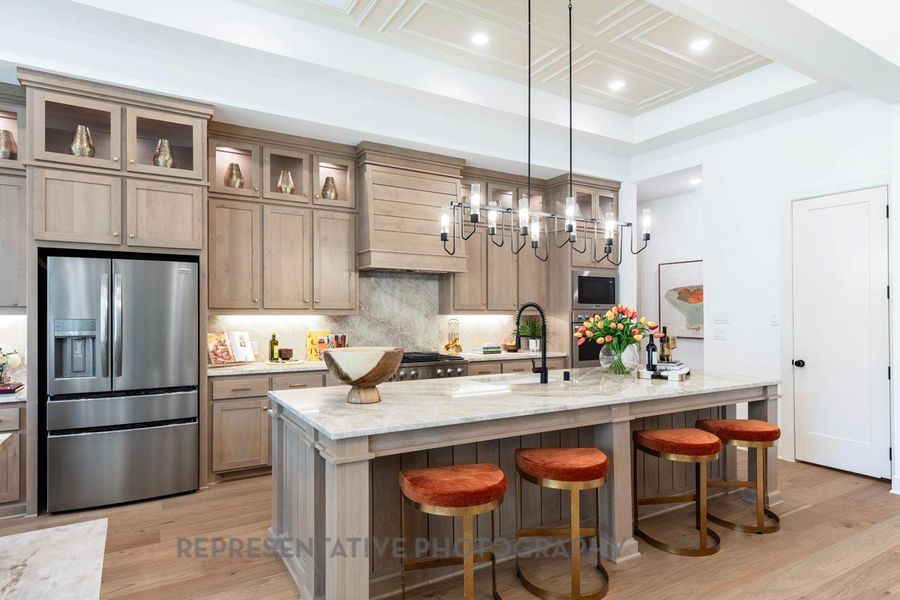 Kitchen featuring stainless steel appliances, recessed lighting, a breakfast bar, light wood-style floors, and light stone counters Kitchen featuring stainless steel appliances, recessed lighting, a breakfast bar, light wood-style floors, and light stone counters