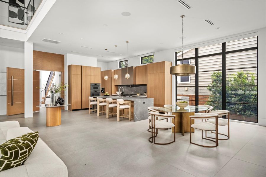 The kitchen, family and breakfast rooms are a great place to gather. The mix of stone, wood and organic materials creates an effortless vibe that is welcoming and relaxing. Note the second staircase shown here. The kitchen, family and breakfast rooms are a great place to gather. The mix of stone, wood and organic materials creates an effortless vibe that is welcoming and relaxing. Note the second staircase shown here.