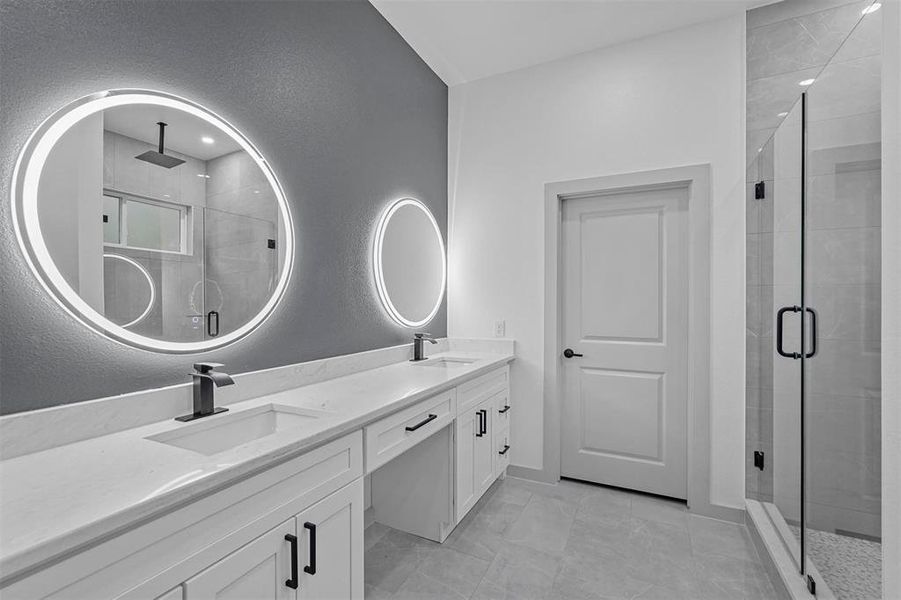 Bathroom featuring vanity and a shower with door