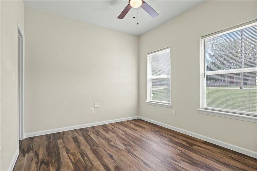 Spare room featuring dark wood-style floors and ceiling fan Spare room featuring dark wood-style floors and ceiling fan
