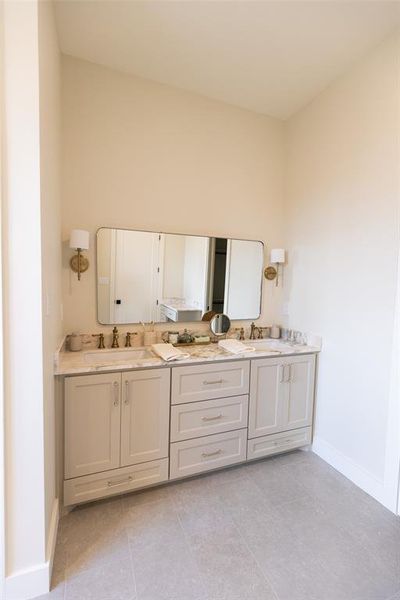 Double vanity featuring light cabinetry, a stone countertop, dual undermount sinks, and a large wall-mounted mirror