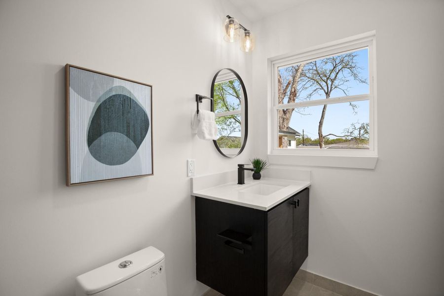 Half bathroom featuring vanity and toilet