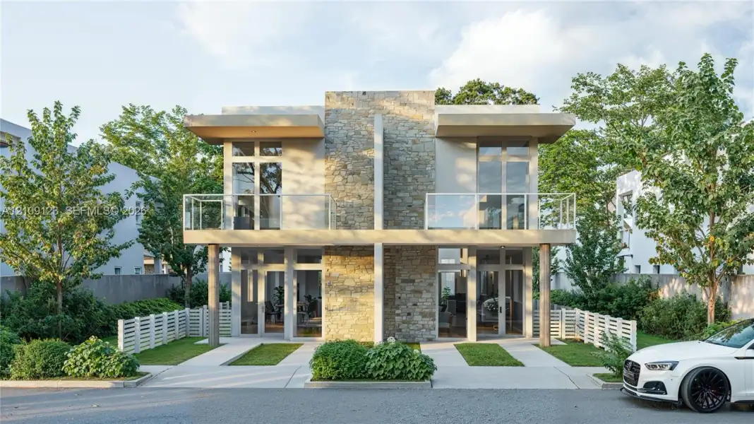 Modern two-story architectural design featuring a natural stone facade, dual upper-level balconies with glass railings, floor-to-ceiling windows, and concrete exterior pillars Modern two-story architectural design featuring a natural stone facade, dual upper-level balconies with glass railings, floor-to-ceiling windows, and concrete exterior pillars