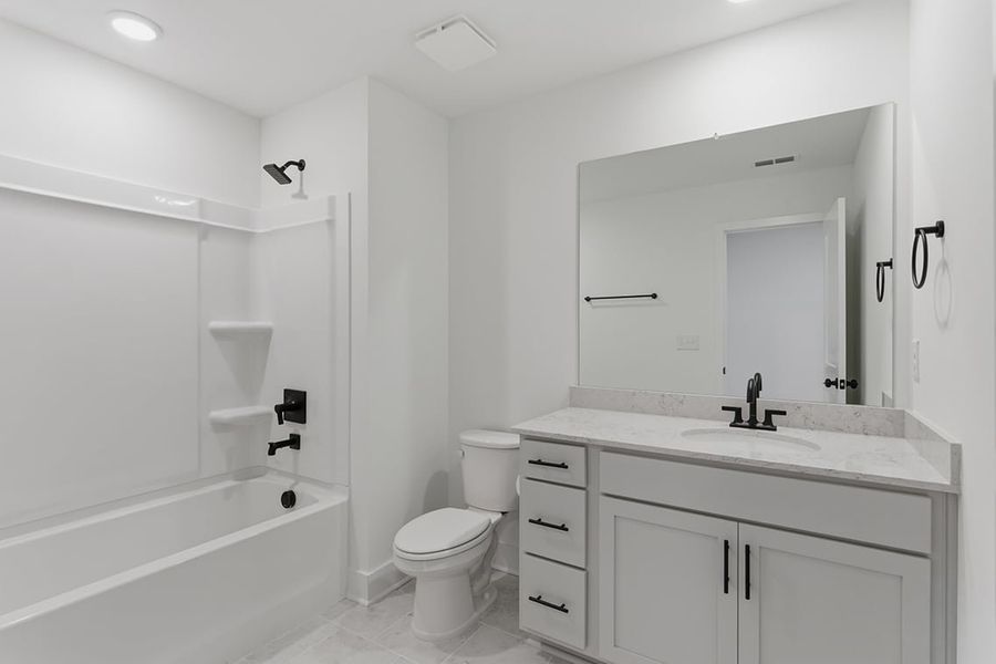 A bathroom with a tub toilet and sink.