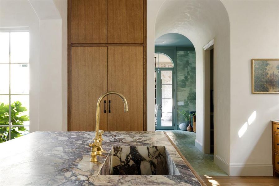 Kitchen featuring brown cabinetry and arched walkways
