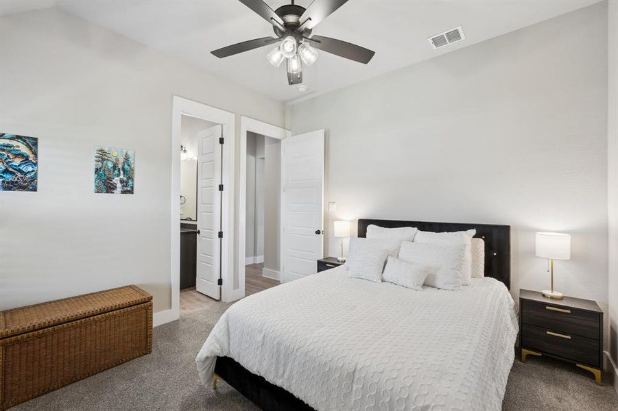 Bedroom featuring carpet, a ceiling fan, and connected bathroom