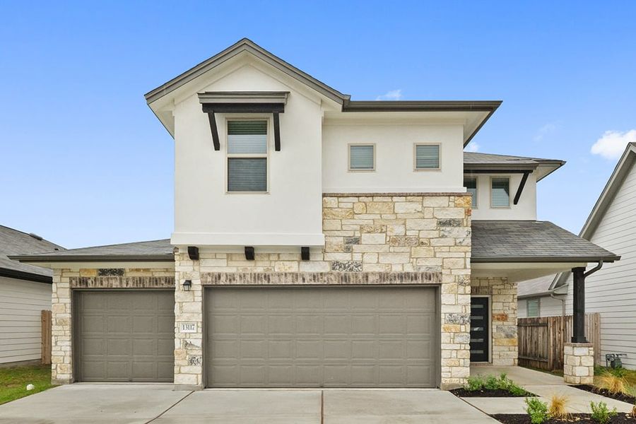 Front exterior of a new home in The Hills of Bear Creek, Manchaca, TX, highlighting curb appeal (Image 27).