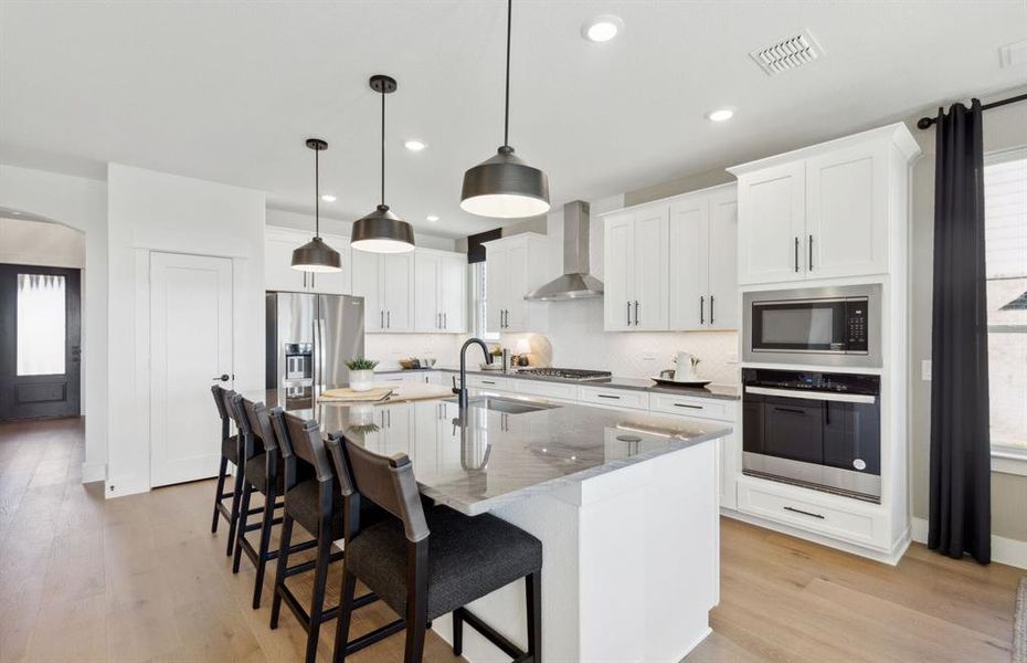 Airy kitchen with oversized island  *Photos of furnished model. Not actual home. Representative of floor plan. Some options and features may vary
