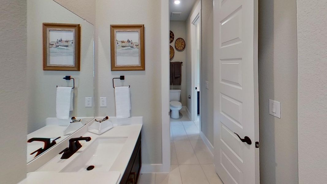 Bathroom featuring vanity, a textured wall, and light tile patterned floors