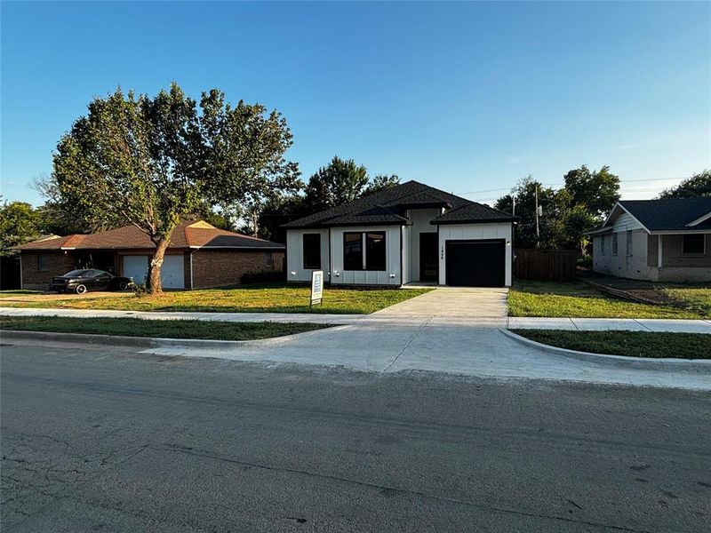 View of front of property featuring a front lawn and a garage