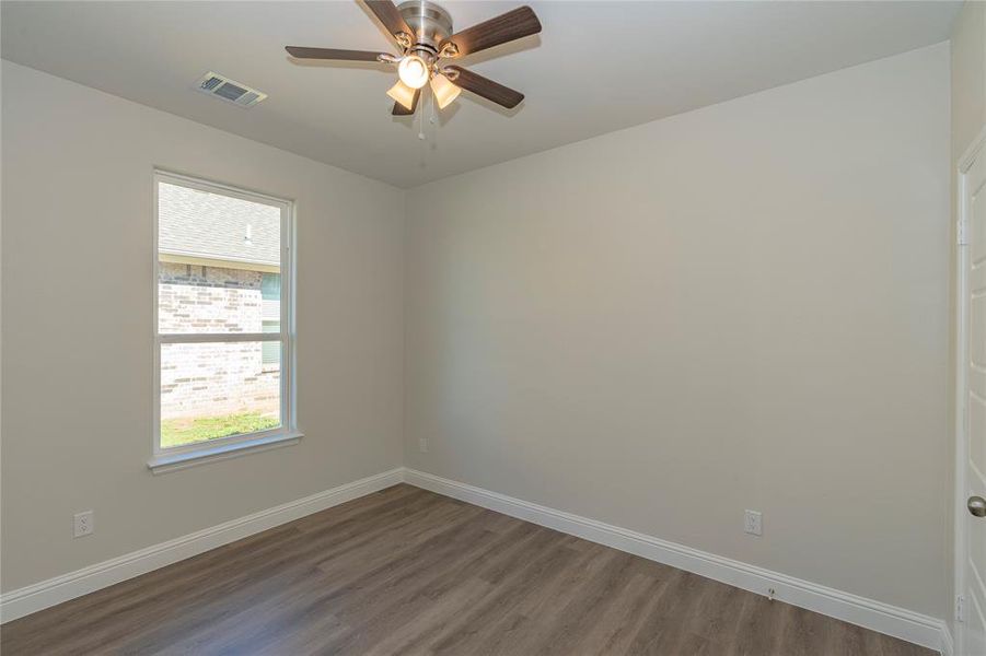 Spare room featuring dark wood-type flooring and ceiling fan