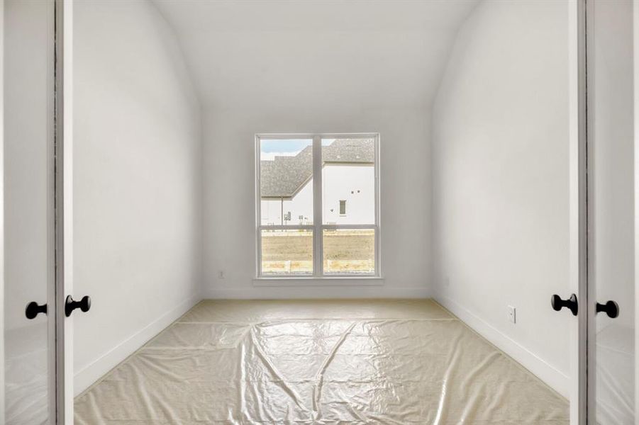 Empty room with french doors and lofted ceiling