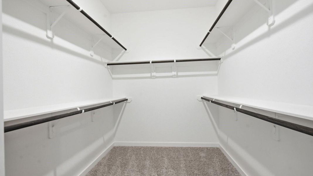 A bedroom shown as an at home office with a bright window allowing natural light to enter.
