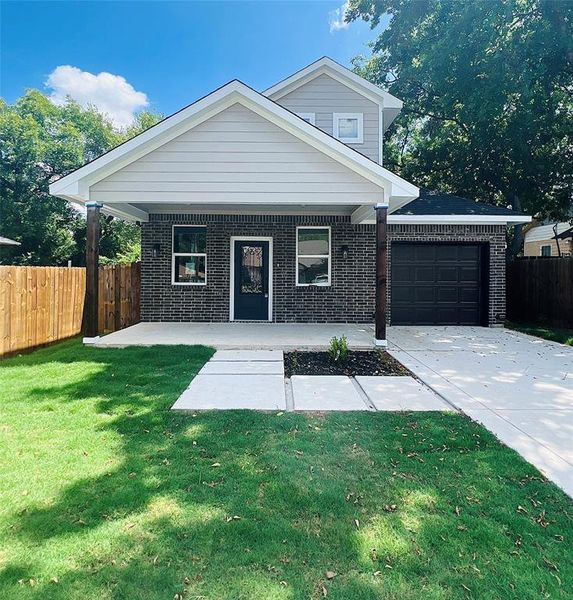 View of front of house featuring a garage and a front lawn