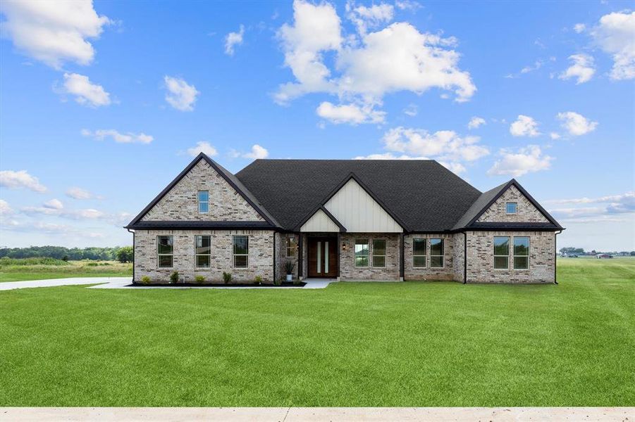 View of front facade featuring a front yard, brick siding, and a shingled roof View of front facade featuring a front yard, brick siding, and a shingled roof