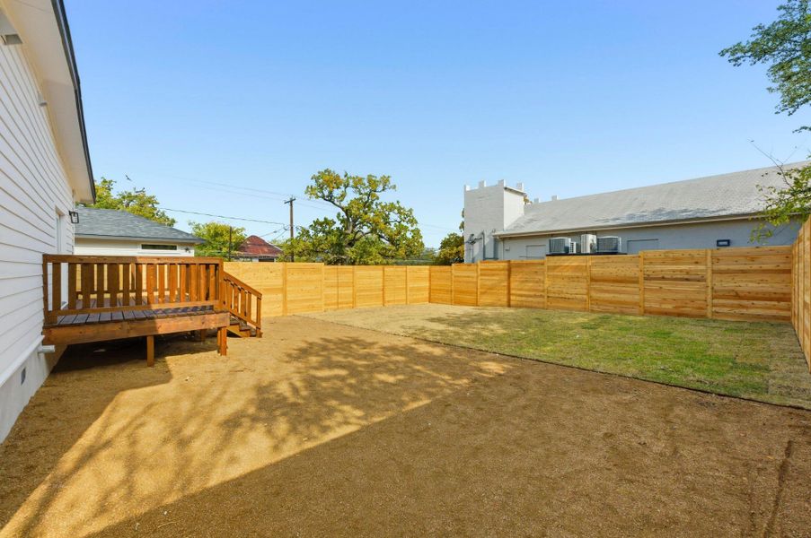 Fenced backyard featuring a deck