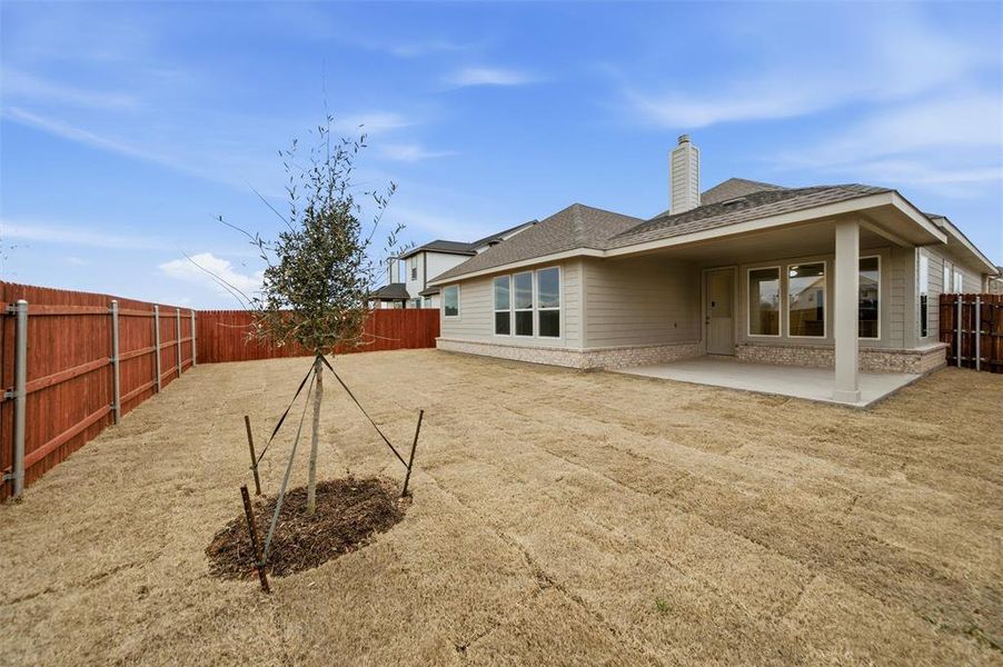 Rear view of house with a fenced backyard, a patio area, a chimney, and roof with shingles