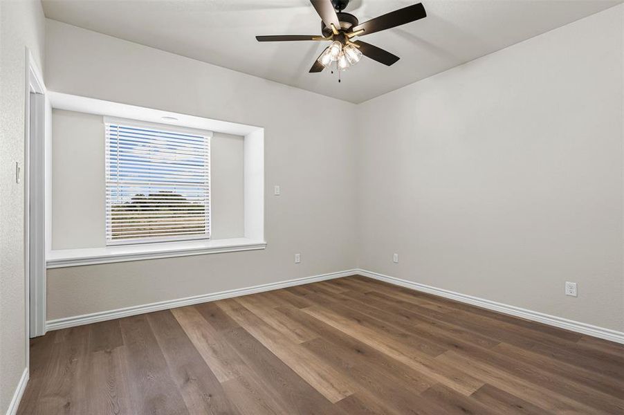 Spare room with wood finished floors and ceiling fan