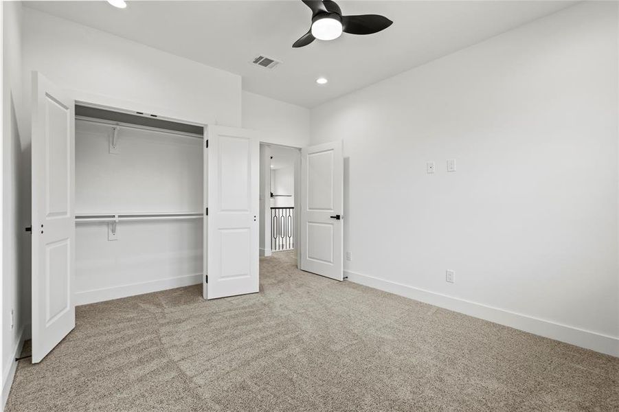 Unfurnished bedroom with light carpet, a closet, and ceiling fan