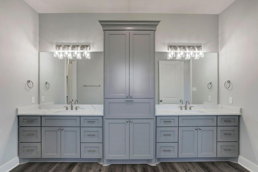 Primary bath with quartz counters, custom cabinetry and dual sinks with a large linen closet. Primary bath with quartz counters, custom cabinetry and dual sinks with a large linen closet.