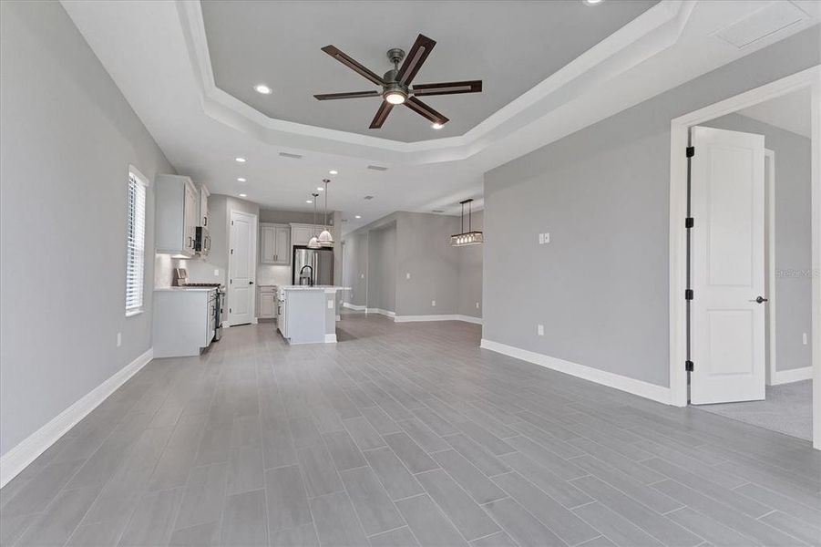 Wood like tile in neutral tones in great room, kitchen, dining and den.