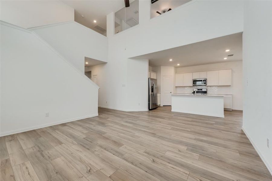 Unfurnished living room with a high ceiling and light hardwood / wood-style flooring