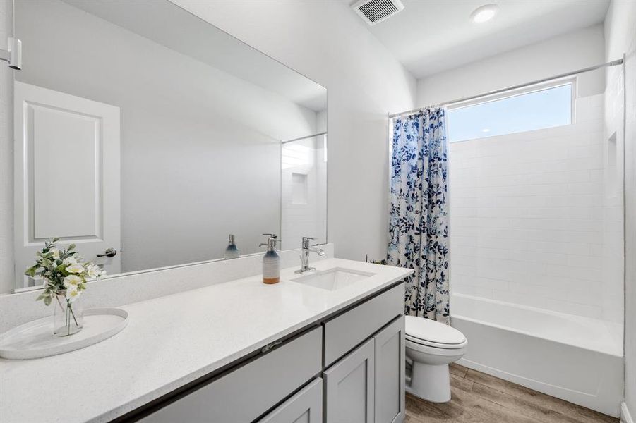 Full bathroom featuring vanity, wood finished floors, and shower / bathtub combination with curtain