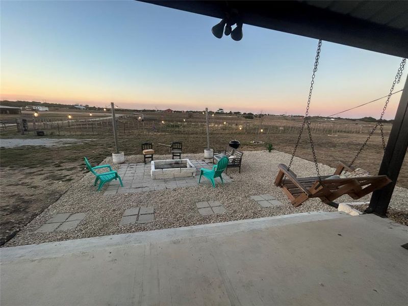 Playground at dusk with a patio area and an outdoor fire pit Playground at dusk with a patio area and an outdoor fire pit