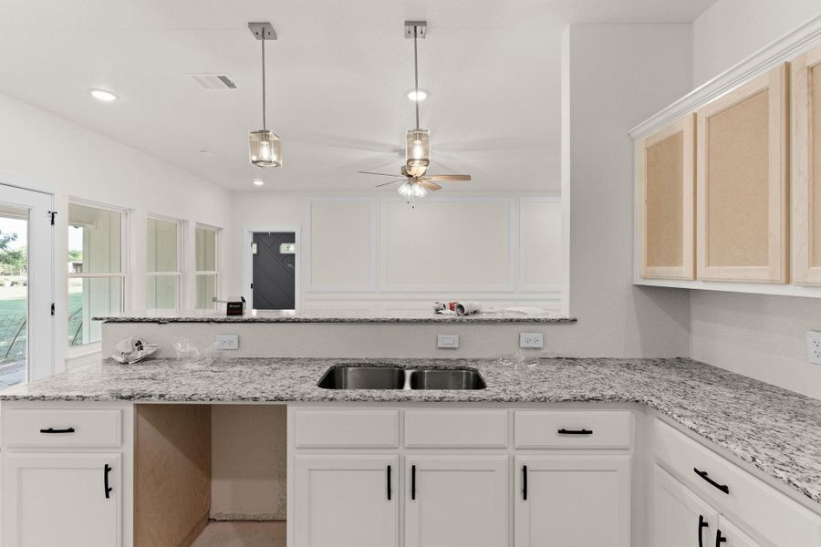 Kitchen featuring a ceiling fan, pendant lighting, light stone countertops, white cabinetry, and recessed lighting Kitchen featuring a ceiling fan, pendant lighting, light stone countertops, white cabinetry, and recessed lighting