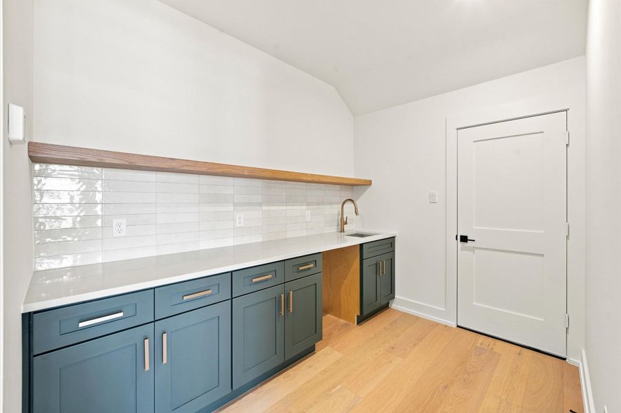 Adjacent bonus room offers storage and utility sink.
