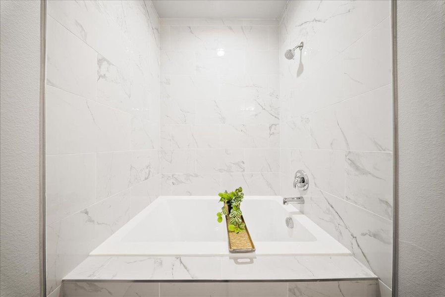 Full bathroom featuring a combined bath / shower with marble appearance Full bathroom featuring a combined bath / shower with marble appearance