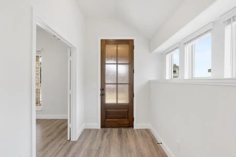 Entryway with wood door featuring glass panels, white walls, and light hardwood floors