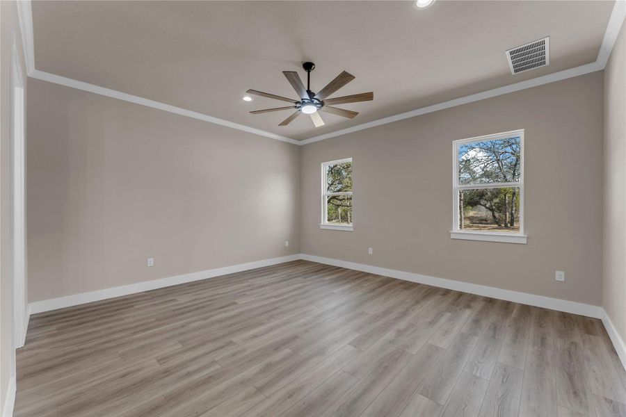 Empty room featuring crown molding, ceiling fan, light wood-style flooring, and recessed lighting