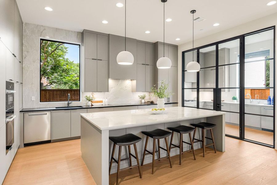 [KITCHEN] The elegant chef's kitchen is a masterpiece of form and function, appointed with premium Miele appliances, including a steam oven, a grand center island, sleek custom cabinetry, and clean architectural lines that define sophisticated contemporary living.