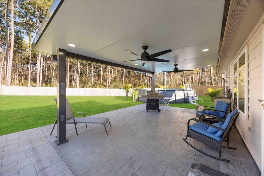 Covered Patio – Outdoor Living SpaceSpacious covered patio designed for year-round enjoyment, featuring ceiling fans, recessed lighting, and ample room for lounging, dining, and grilling. Overlooking the expansive backyard with no back neighbors, this private outdoor retreat is ideal for entertaining, relaxing, or enjoying quiet evenings outdoors. A seamless extension of the home that elevates both everyday living and gatherings. Covered Patio – Outdoor Living SpaceSpacious covered patio designed for year-round enjoyment, featuring ceiling fans, recessed lighting, and ample room for lounging, dining, and grilling. Overlooking the expansive backyard with no back neighbors, this private outdoor retreat is ideal for entertaining, relaxing, or enjoying quiet evenings outdoors. A seamless extension of the home that elevates both everyday living and gatherings.