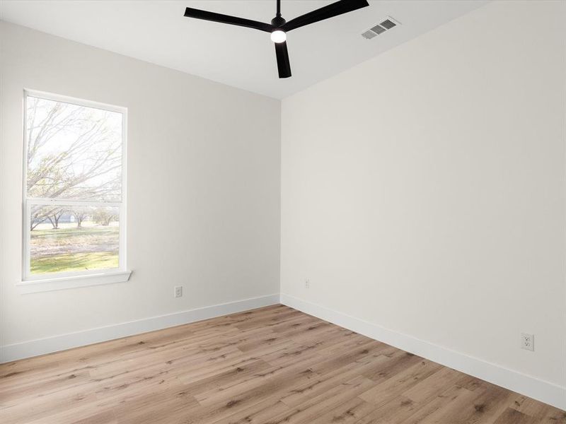 Empty room featuring light wood-type flooring and ceiling fan