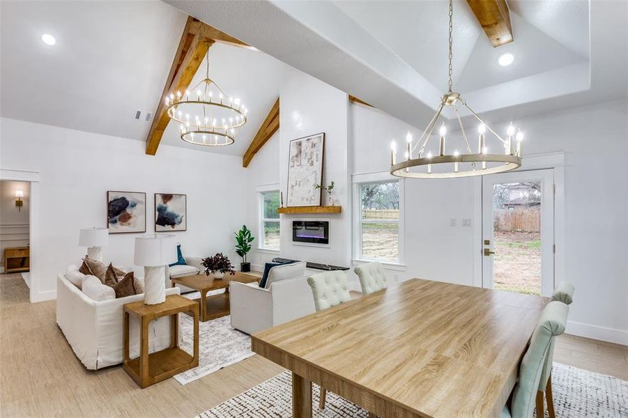 Dining room featuring beamed ceiling, high vaulted ceiling, an inviting chandelier, and light hardwood / wood-style flooring