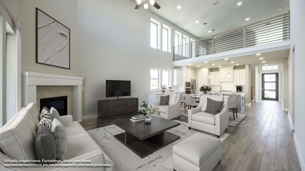 Living room featuring light wood-type flooring, a ceiling fan, and a wealth of natural light Living room featuring light wood-type flooring, a ceiling fan, and a wealth of natural light