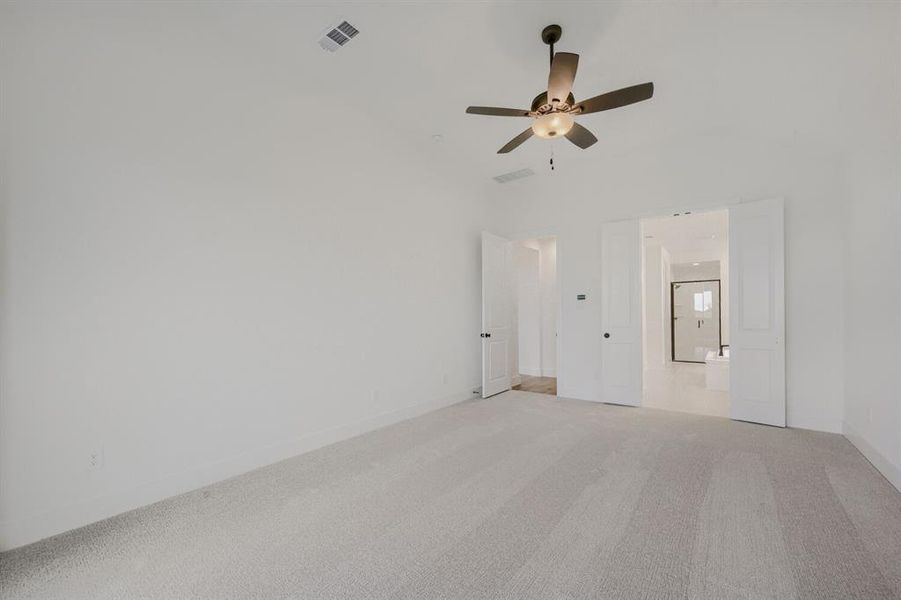 Spacious room featuring vaulted ceilings and light-colored carpeting