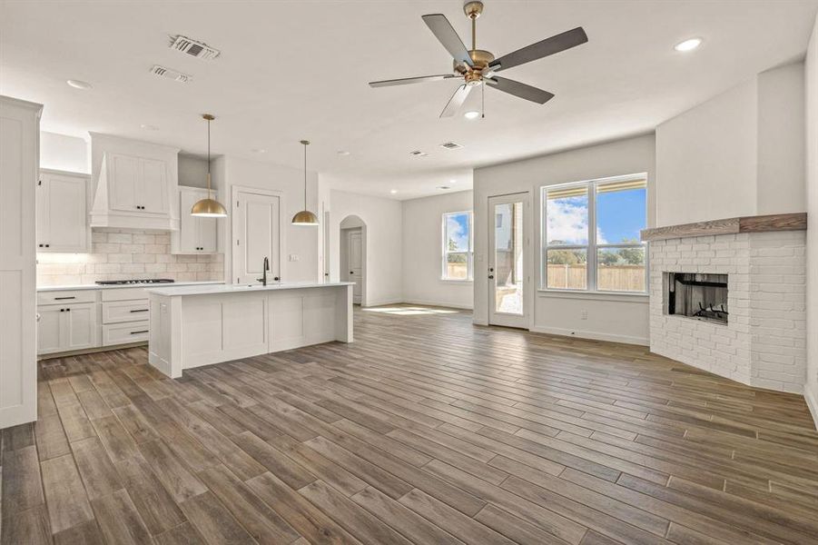 Kitchen with open floor plan, stovetop, dark wood-style floors, and recessed lighting
