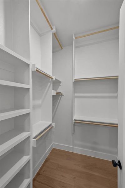 Walk in closet with hardwood / wood-style floors