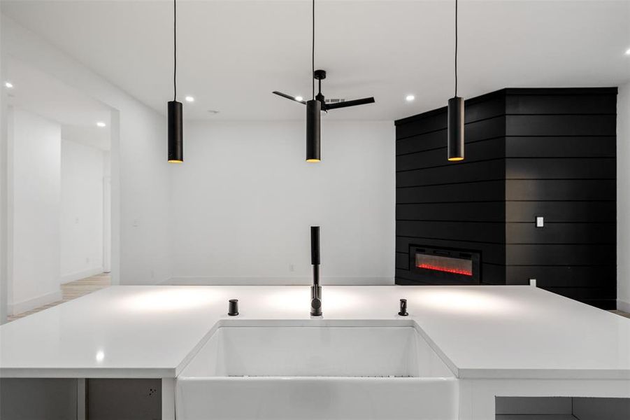 Kitchen with sink, a large fireplace, and hanging light fixtures