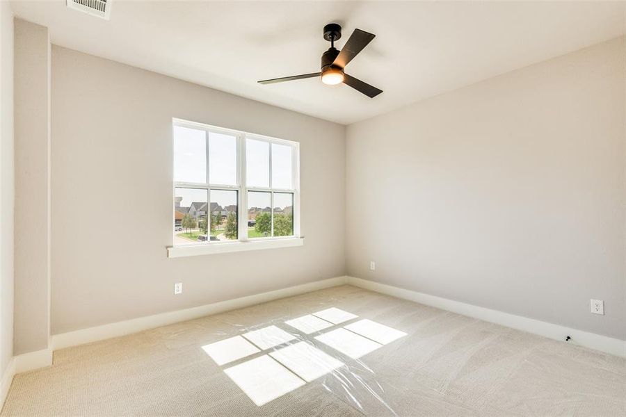 Carpeted empty room with ceiling fan