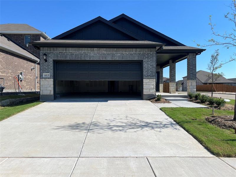 Ranch-style house with board and batten siding, a garage, stone siding, concrete driveway, and covered porch