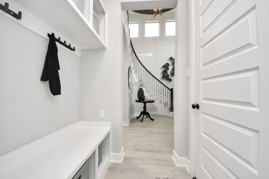 Mudroom nook by the entry with bench, hooks, and organizational storage