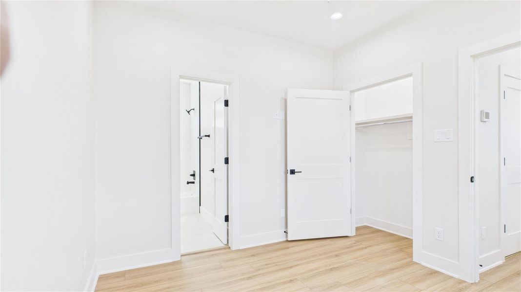 Experience tranquility in this bright, inviting third-floor secondary bedroom, featuring sleek wood flooring and a convenient en-suite bathroom.