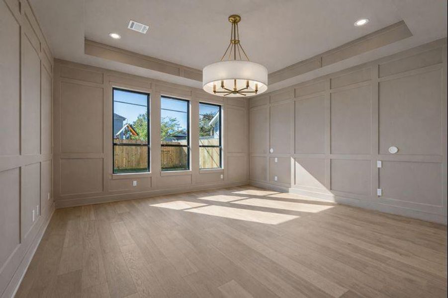 Downstairs primary suite features accent wall, chandelier, wall sconces, box tray ceiling *photos are of a previously constructed home by the builder. 1359 Wakefield may have different selections at builders sole discretion. These photos are not meant to be an exact representation of 1359 Wakefield.
