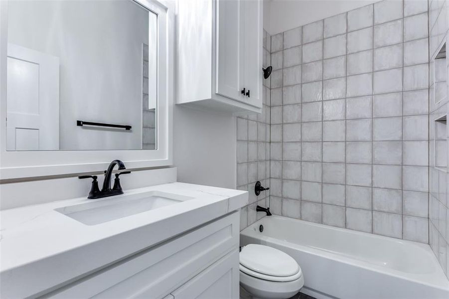 Bathroom with shower / bathing tub combination, vanity, and toilet